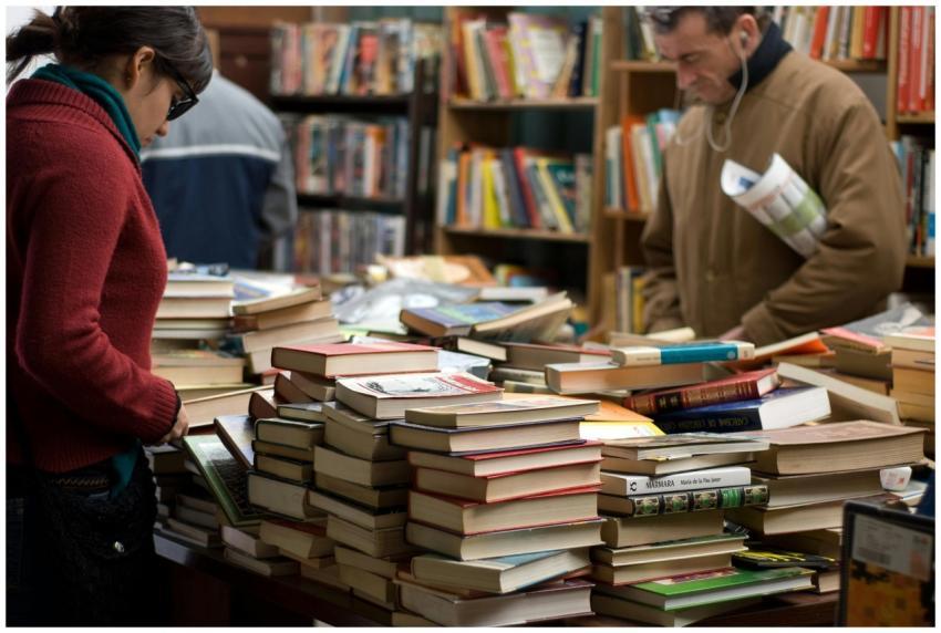 People browsing a large selection of books at a bo