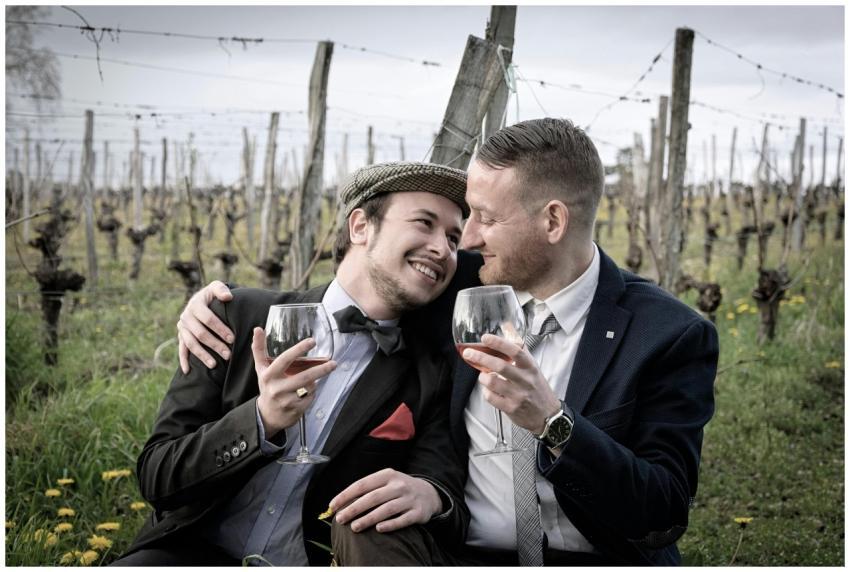 Happy couple in vineyard hugging and sharing a gla