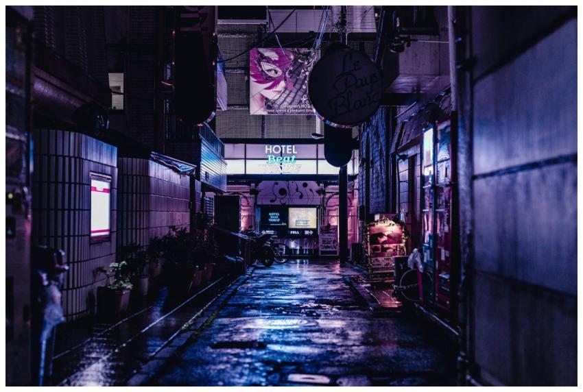 A vivid night scene capturing a wet alley in Tokyo