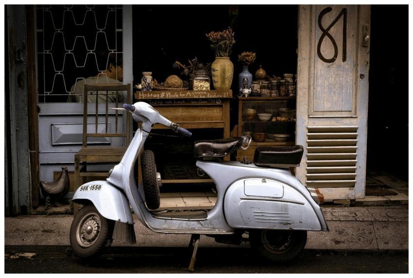 A classic Vespa scooter parked in front of a charm