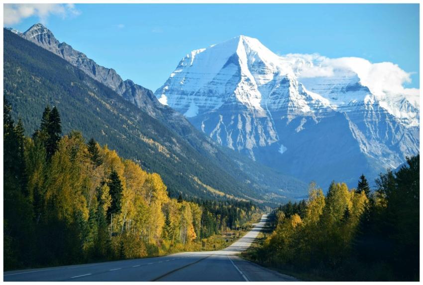 Stunning autumn scene with a road leading to a sno
