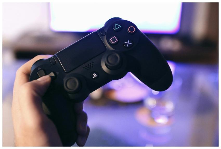 Person holding a gaming controller, blurred screen