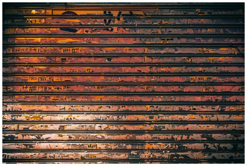 A close-up of a rusty metal shutter adorned with c