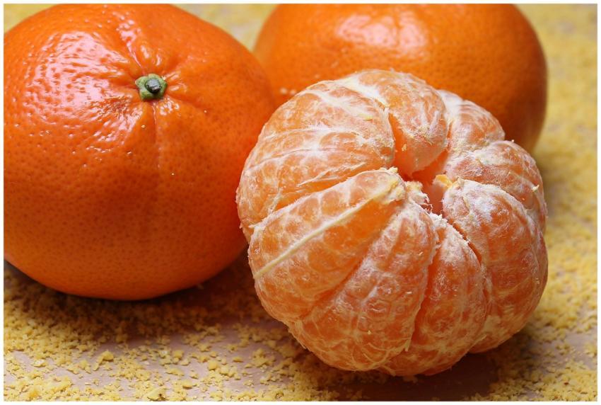 Close-up of fresh clementines and a peeled segment