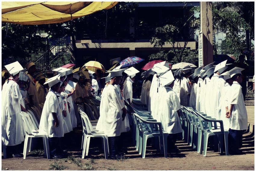 Group of children in academic gowns celebrating gr