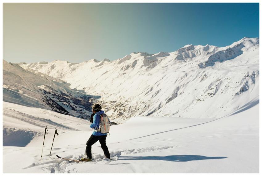 A skier enjoying a sunny day on snow-covered slope