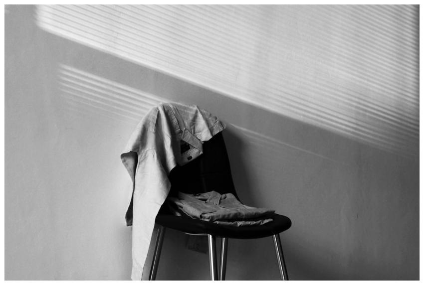 A monochrome image showcasing a chair draped with