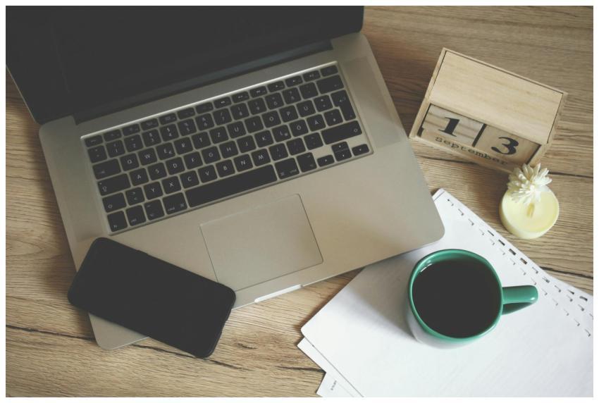 Modern office desk setup with laptop, smartphone,