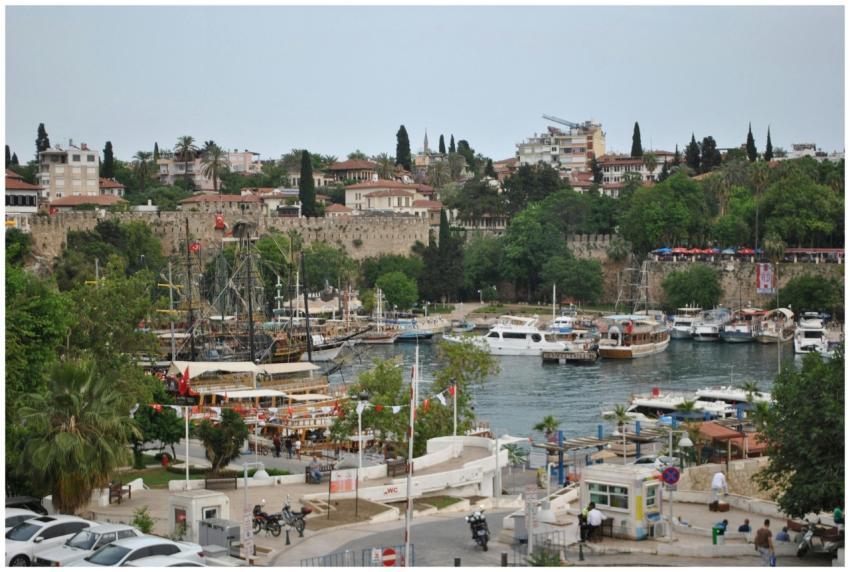 Bustling Antalya harbor with boats, historic build