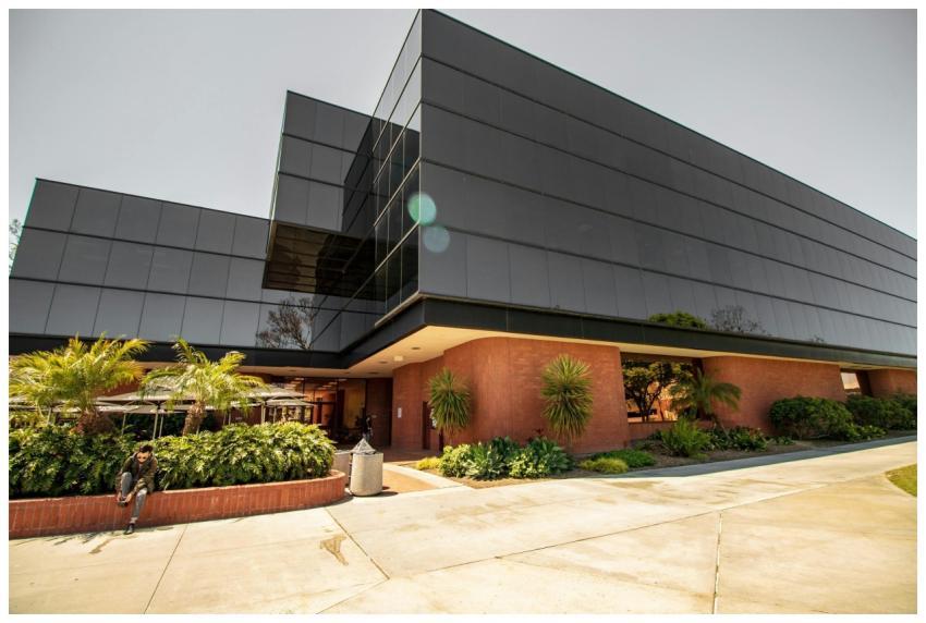 A contemporary glass building with lush plants and