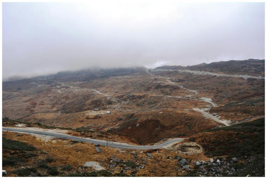 Winding road through mist-covered mountains in Gan