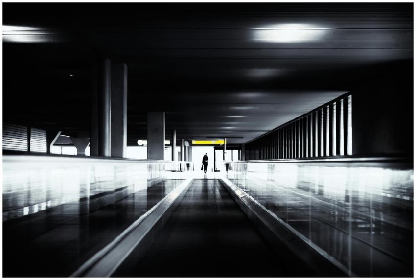 Silhouette of a person walking through a dark, mod