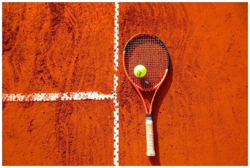 Tennis racket and ball on red clay court, ideal fo