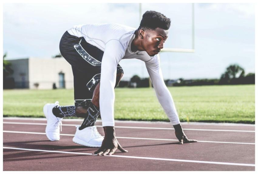 Focused athlete in starting position on a sunny tr