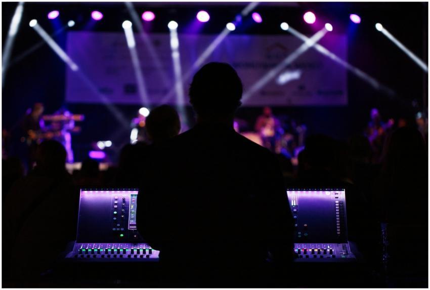 A sound engineer manages the audio mixer during a