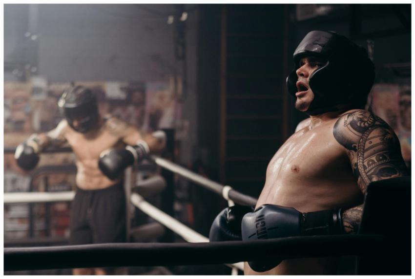 Two boxers engaged in a sparring session in a gym,