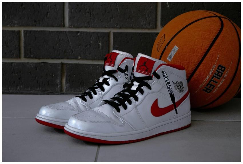 White and red basketball sneakers with an orange b