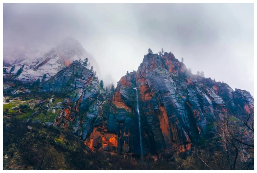 A stunning mountain peak enveloped in fog features