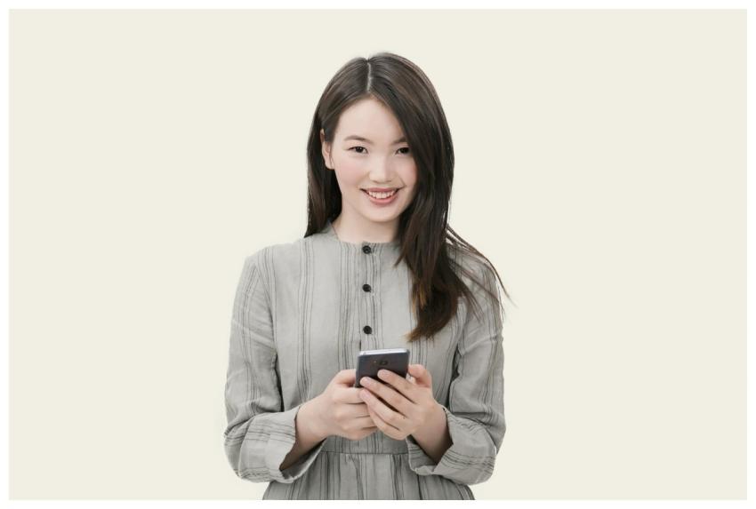 Smiling woman with long hair using her smartphone,