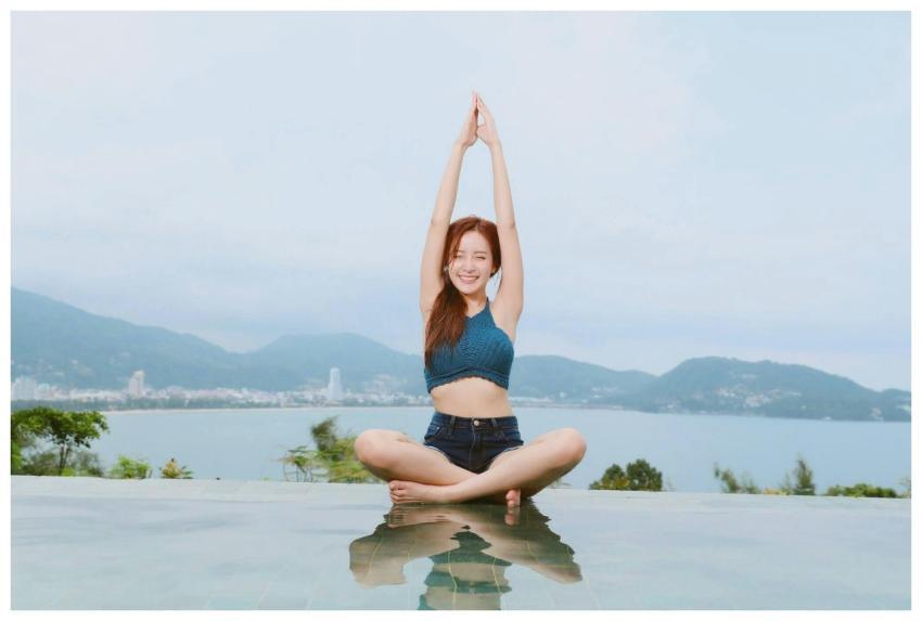 Young woman doing yoga by a scenic waterfront, enj