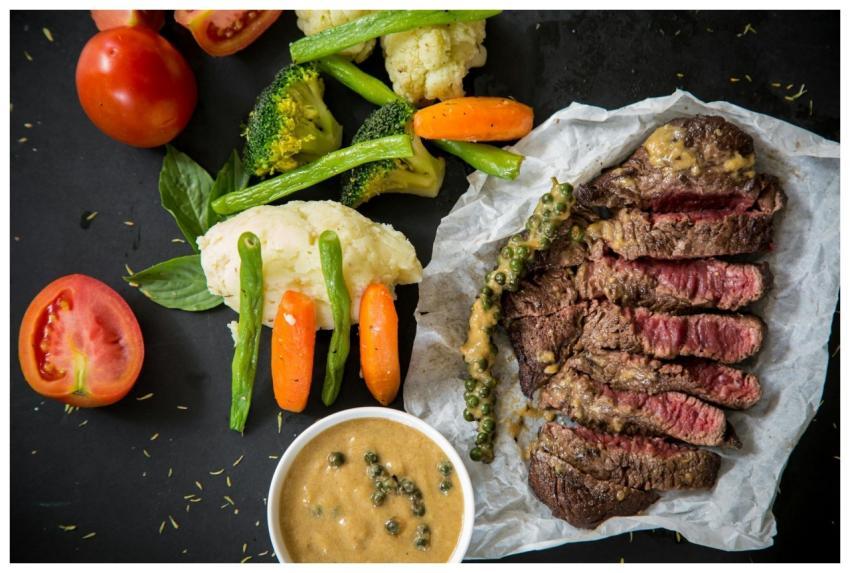 Grilled steak served with fresh vegetables and pep