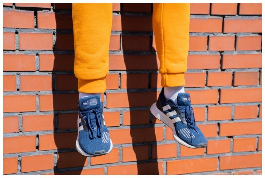 Casually dressed man sitting on a brick wall. He’s