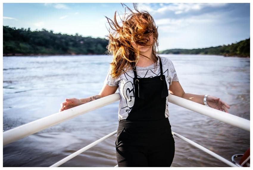 Carefree young woman smiling as wind blows her hai