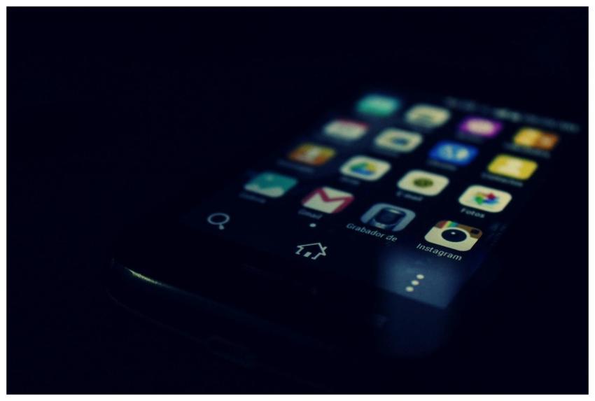 Dark-themed close-up of a smartphone screen highli