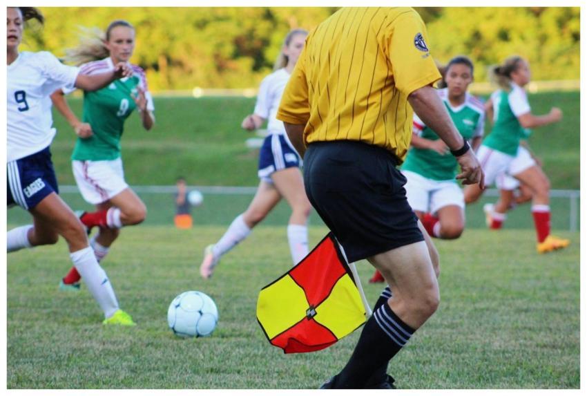 Women's soccer match featuring players and referee