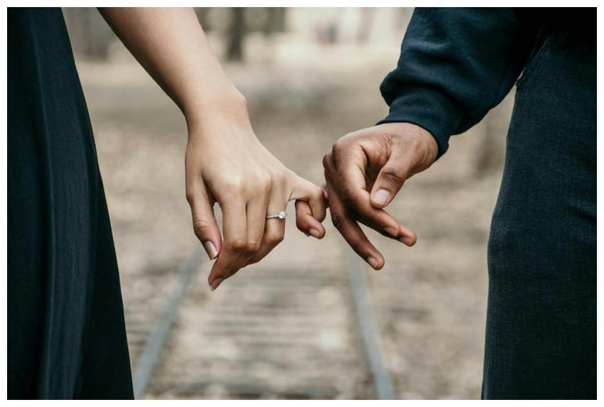 A romantic couple holding hands, symbolizing love