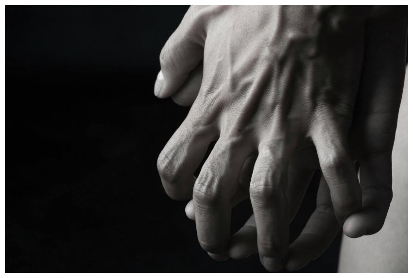 Monochrome close-up of intertwined hands, showcasi
