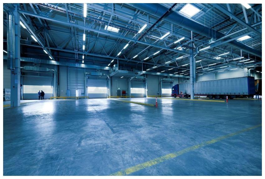 Large warehouse interior with docked truck, ideal