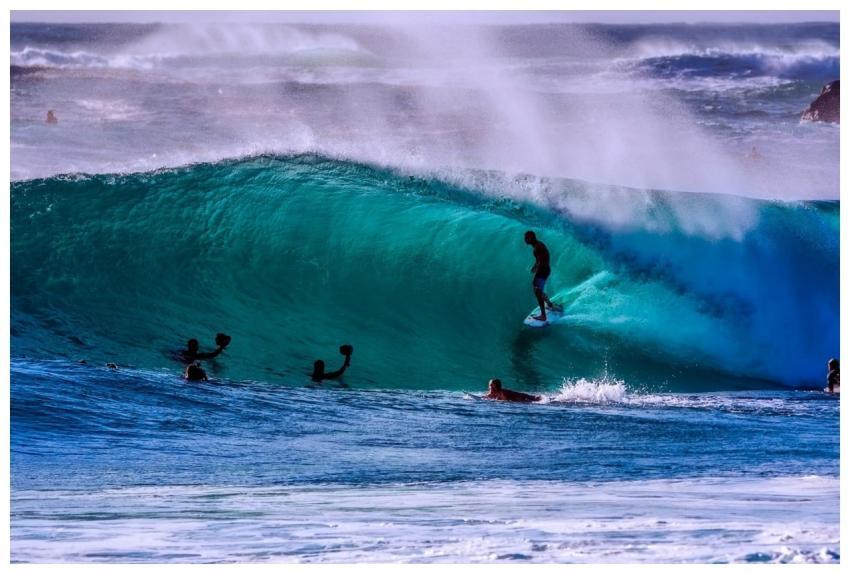 Dynamic surfing action on a bright ocean wave duri