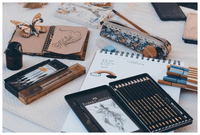 Art supplies including pencils, pens, and sketchbo