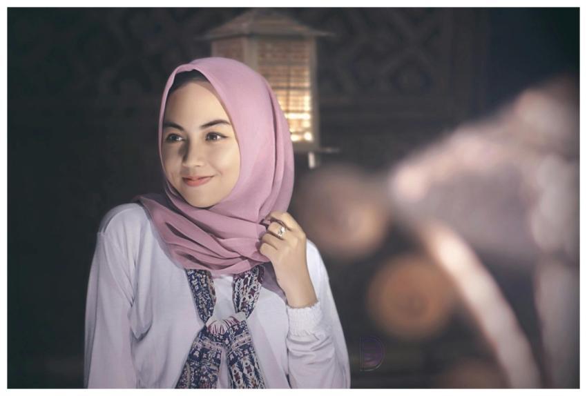 A serene portrait of a woman wearing a pink hijab,