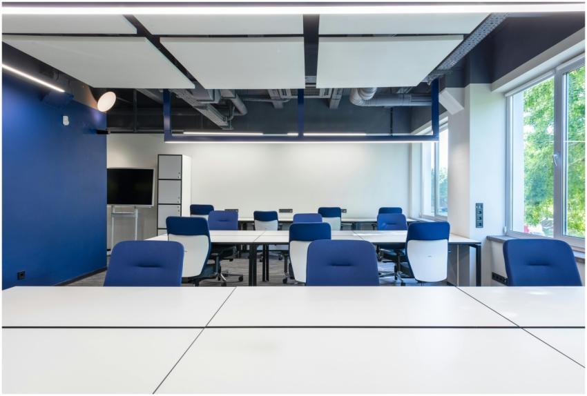 Various white desks with blue chairs placed in mod
