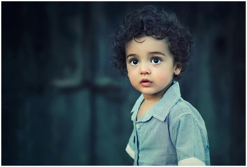 Charming portrait of a young boy with curly hair a