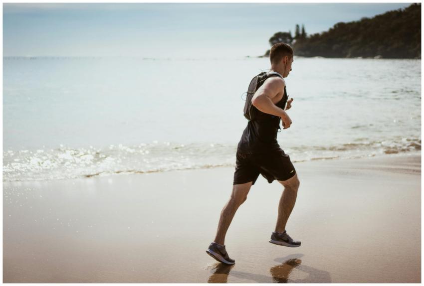 Man running along the beach enjoying fitness and f