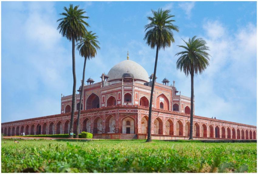 Humayun's Tomb surrounded by palm trees under a cl