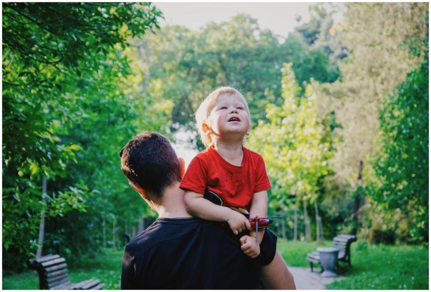 A father carrying his son on his shoulders as they