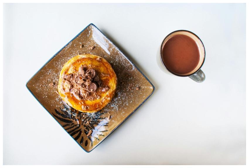 Chocolate pancakes topped with shavings accompanie