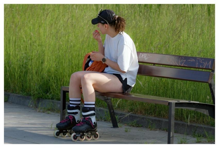 Woman Rollerblades Park Sitting