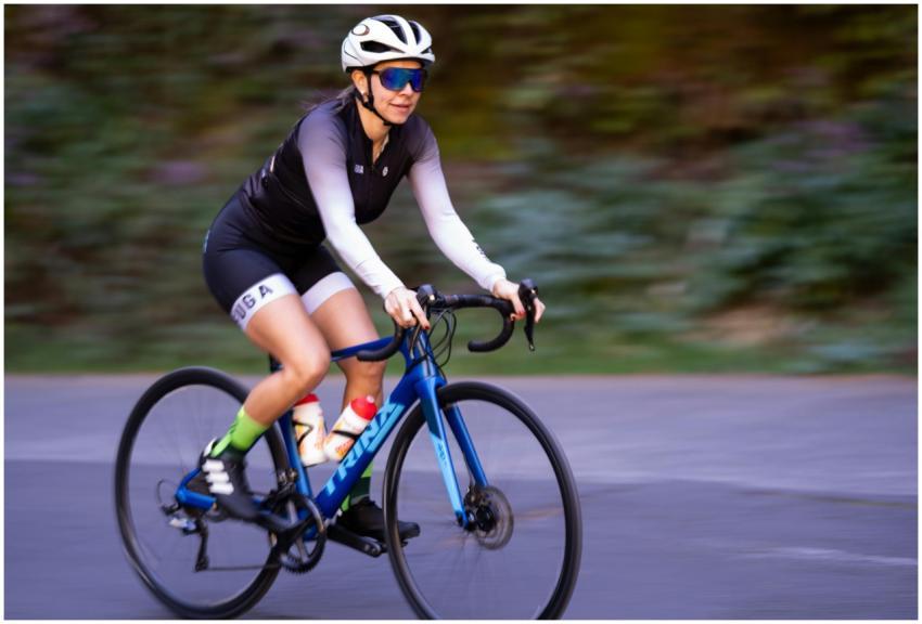Female cyclist in motion on a road bike during day