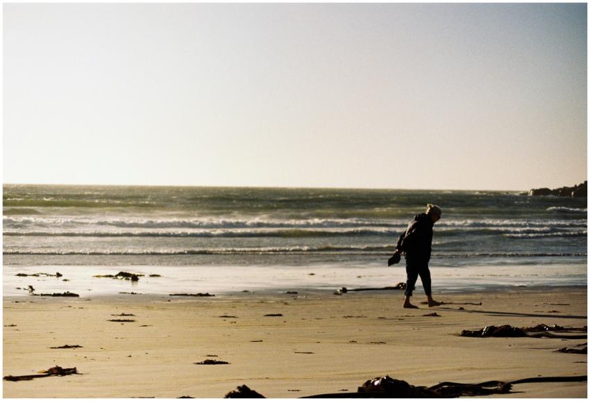 A lone person walking along a tranquil beach with