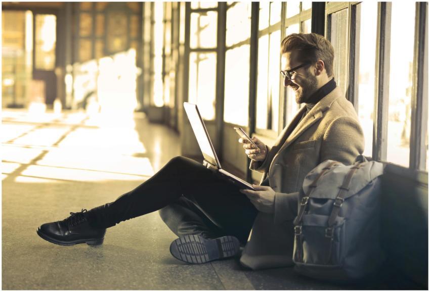 Man sitting with a laptop and smartphone, represen