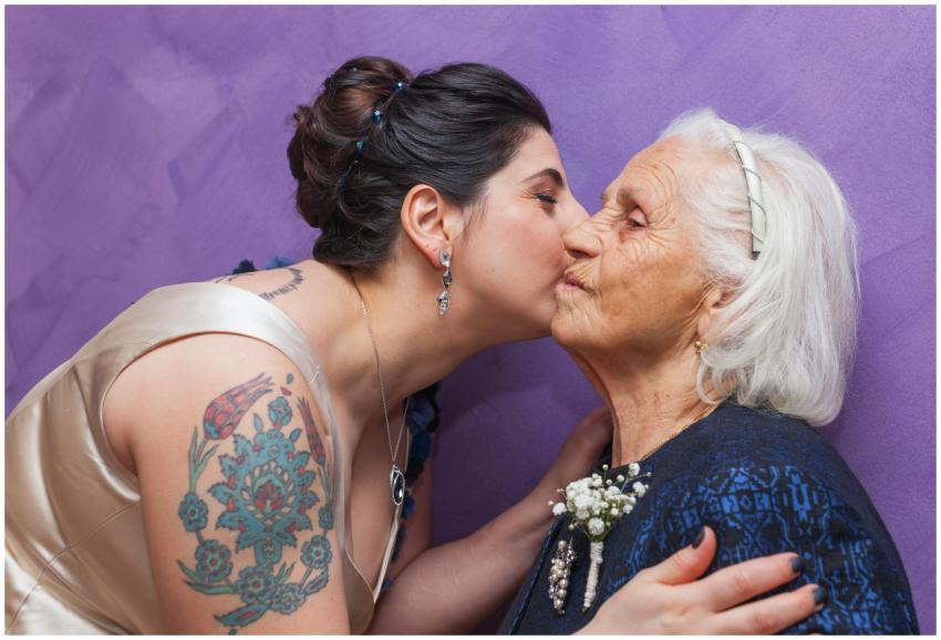 A young woman affectionately kisses her elderly gr