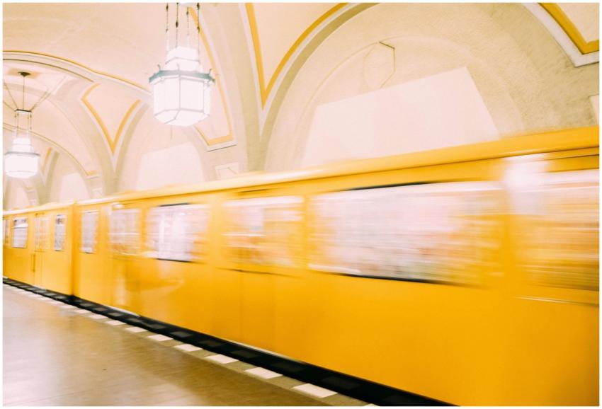 A vibrant yellow train speeds through a Berlin sub