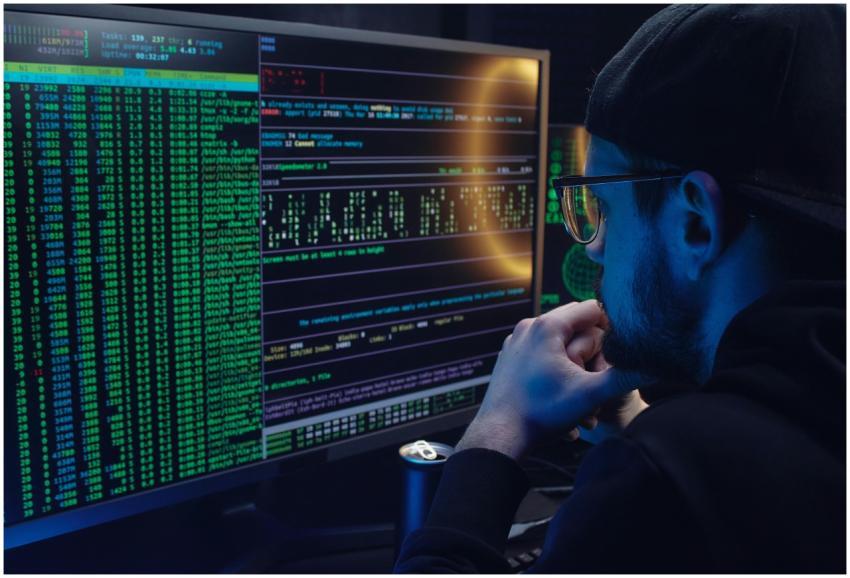 Man intently working on computer programming with
