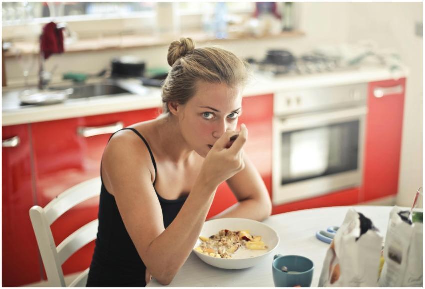 Woman eating a healthy breakfast with cereal and m