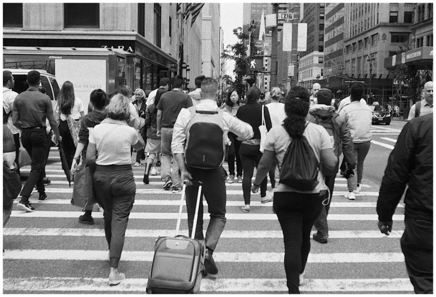 A black and white image of pedestrians crossing a
